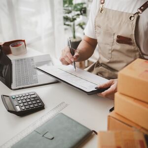 Man working, online shop owner checking orders from websites on the internet to confirm orders with customers who have ordered them and packing them for delivery. Concept of selling products online.