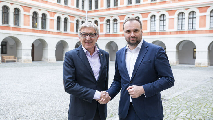Josef Herk, Präsident der Wirtschaftskammer Steiermark, und Michael Sacherer, Präsident der Ärztekammer Steiermark, reichen sich die Hand.