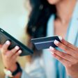 Bank card data put in phone by a lady who does internet banking by typing on her mobile to make an online credit payment. Young woman texting on her phone to send money via an ewallet transaction.