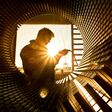 Ein Techniker bei der Arbeit, fotografiert bei Gegenlicht durch einen riesigen Rotor.