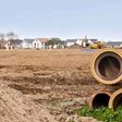 rohr, neubaugebiet, gelände, erschliessen, erschliessung, tonrohr, erdarbeiten, feld, acker, bauland, baumaschine, bagger, lkw, haus, sand, himmel, blau