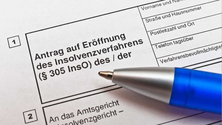 nahaufnahme auf kugelschreiber auf antragspapier für insolvenzmeldung