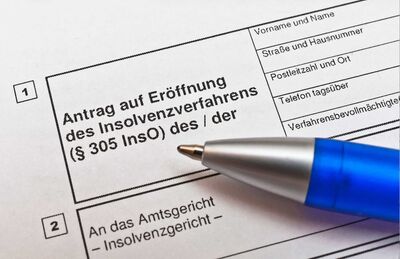 nahaufnahme auf kugelschreiber auf antragspapier für insolvenzmeldung