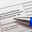 nahaufnahme auf kugelschreiber auf antragspapier für insolvenzmeldung