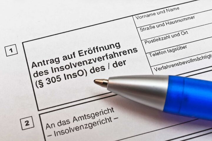 nahaufnahme auf kugelschreiber auf antragspapier für insolvenzmeldung