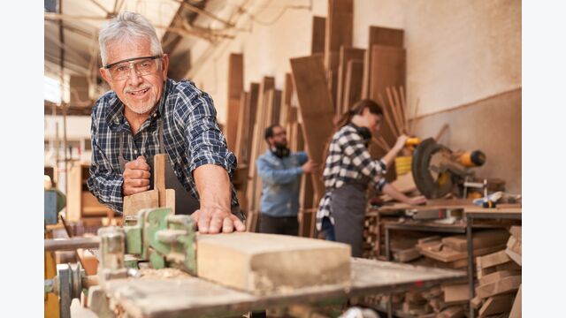 Handwerker als erfahrener Meister beim Holz hobeln in der Schreinerei Werkstatt