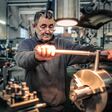Ein älterer Mechaniker arbeitet an einer Maschine.