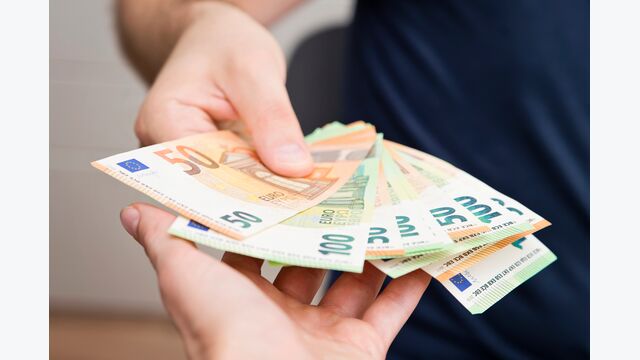 Euroscheine wechseln von einer Hand in eine andere.
