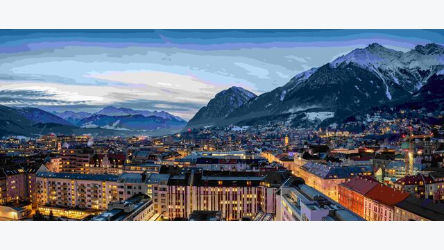 Panorama der Skyline von Innsbruck, Alpen, Österreich, im Winter am Abend mit schneebedeckten Bergen im Hintergrund