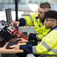 Zwei männliche Techniker sitzen an einem Computertrainingsprogramm im Automatisierungsbereich.