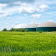 Biogasanlage in Deutschland mit Getreidefeld unter blauem Himmel