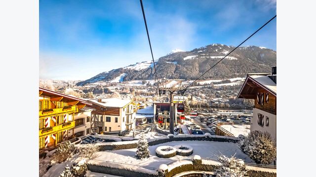 Luftansicht auf eine Skigondel im halbverschneiten Kitzbühel, Tirol.