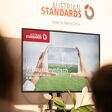 Ein Bildschirm zeigt das Coverbild mit Logo des 7. Baustammtisches von Austrian Standards.