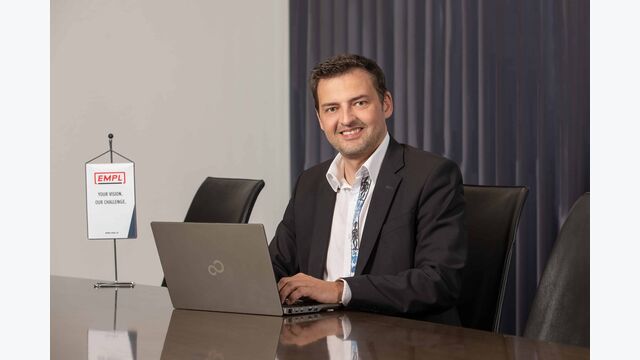 Portraitbild von Joe Empl, CEO Empl Fahrzeugwerk, an einem Schreibtisch sitzend und am Laptop schreibend.