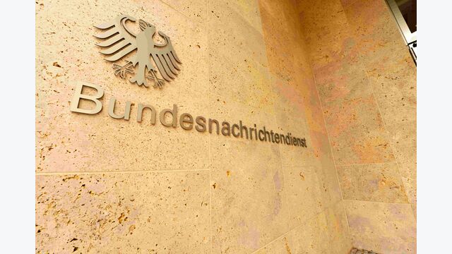 Schriftzug des deutschen BND (Bundesnachrichtendienst) mit Staatsadler auf einer Gebäudemauer.