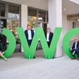 Andreas Pötsch, Hans Schaffer und Christian Krainer von ÖWG Wohnbau Graz, sowie Claudia Nutz von nutzeffekt posieren mit riesigen grünen ÖWG-Buchstaben