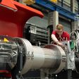 Arbeiter an einer großen Fertigungsmaschine bei der Wiener Firma Starlinger & Co.