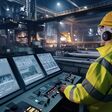 Ki-generiertes bild eines Stahlwerksmitarbeiters, der KI-gesteuerte Temperaturregelungen in einer hochtechnologischen Industrieumgebung überwacht.