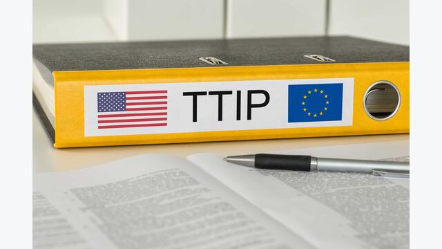 Gelber Aktenordner mit der Beschriftung TTIP, einer US-Flagge und einer EU-Flagge darauf
