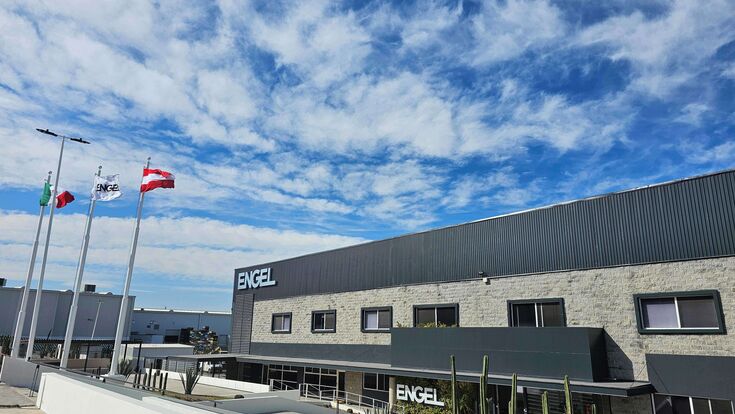 © Engel Group Außenansicht auf den Industrie- und Produktionsstandort in Mexiko des oberösterreichischen Spritzgussmaschinenbauers Engel bei blauem Himmel und wehenden Flaggen.