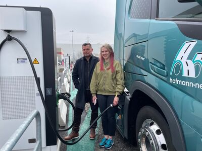 © elexon GmbH Elisabeth Andrieux, Geschäftsführerin von hofmann & neffe, und Marcus Scholz, CEO der elexon GmbH, neben einem E-Lkw beim Aufladen.