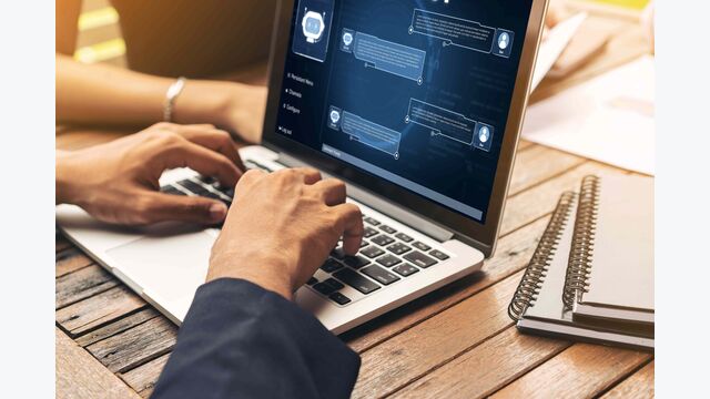 Hände an einem Laptop, auf dem ein Chat geöffnet ist - möglicherweise mit generativer KI