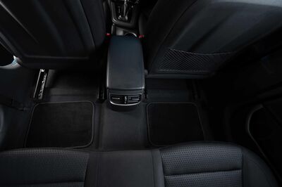 schwarzer Fußbereich in einem Auto, sauber und mit Teppich ausgelegt