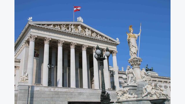 seitliche Außenansicht auf das österreichische Parlament in Wien bei blauem Himmel