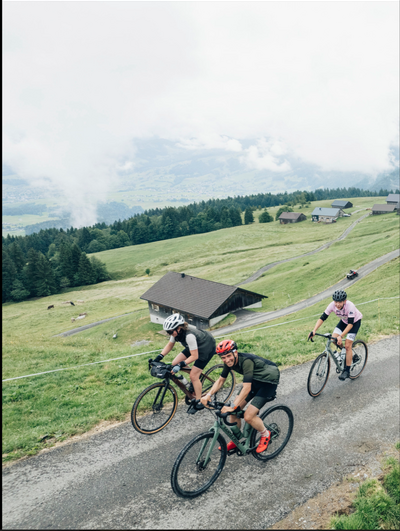luftansicht auf drei radfahrer im rahmen des events "into the wold" in vorarlberg