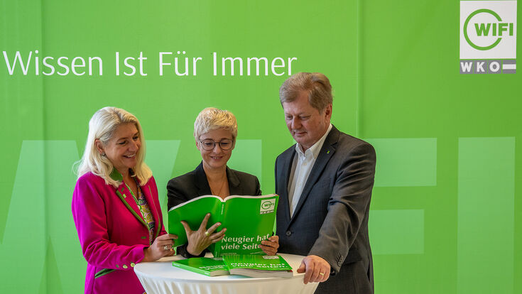 WIFI-Kuratorin Doris Cuturi-Stern, WKOÖ-Präsidentin Doris Hummer, WIFI-Institutsleiter Harald Wolfslehner blättern an einem Stehtisch im WIFI-OÖ-Kursbuch