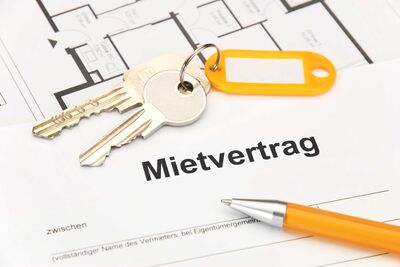 Kugelschreiber und Wohnungsschlüssel liegen auf einem Mietvertrag.