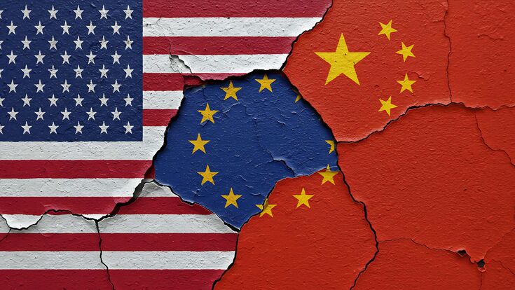 symbolisches bild dreier ineinander greifender flaggen - usa, eu und china - als abblätternde mauer dargestellt