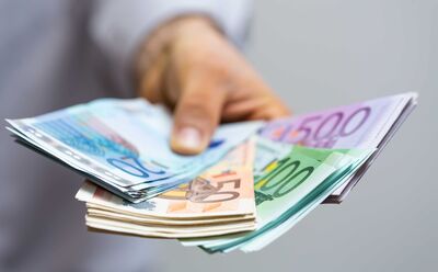 Nahaufnahme einer Hand, die mehrere Euro-Banknoten aufgefächert hält