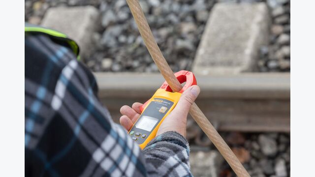Nahaufnahme von ÖBB-Mitarbeiter bei Hochspannungsprüfung mithilfe eines Handhelds