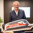 Rudolf Bredschneider, Obmann der WK-Bezirksstelle Völkermarkt, mit einem großen Schild, das einen Zug zeigt.