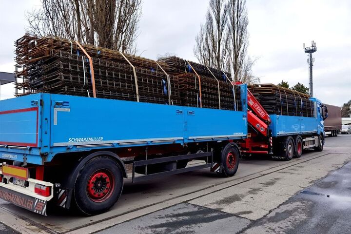 Blauer offener Lkw des Unternehmens AVI voll beladen mit Betonbewehrungsprodukten