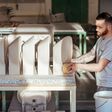 Ein Laufen-Mitarbeiter in der Produktion neben einer Reihe Waschbecken