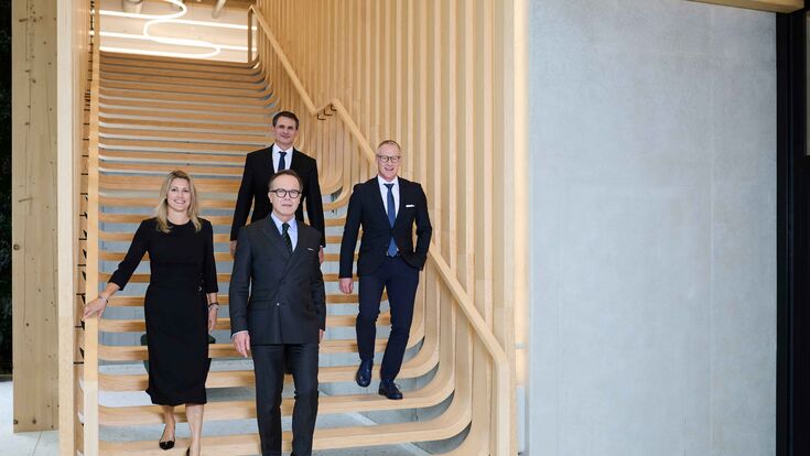 Der vierköpfige UBM-Vorstand auf einer Treppe aus Holz