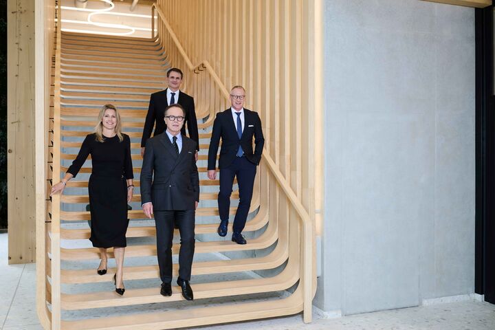 Der vierköpfige UBM-Vorstand auf einer Treppe aus Holz