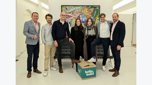 Team des Wiener Hundefutter-Herstellers HelloBello mit einer grünen Box des Produkts.