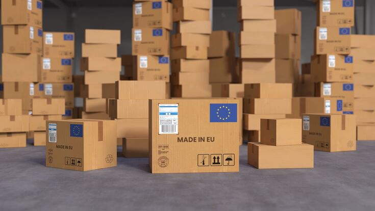 viele übereinandergestapelte braune kartonboxen mit eu-logo und vermerk "made in eu" darauf