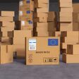 viele übereinandergestapelte braune kartonboxen mit eu-logo und vermerk "made in eu" darauf