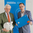 Georg Bucher, Vorstandsvorsitzender, und Oliver Kröpfl, Vorstandsmitglied der Steiermärkischen Sparkasse mit überdimensioniertem Sparschwein und Debitkarte