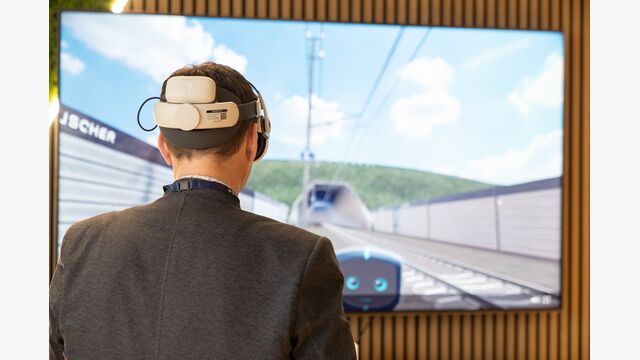 mann von hinten blickt mit VR-Brille auf einen simulierten Bahnabschnitt