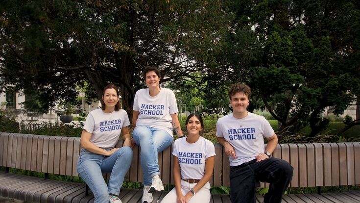 Das österreichische Team der Hacker School auf einer Bank im Freien