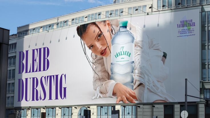 Große Werbefläche mit Vöslauer Mineralwasser Kampagne, die Künstlerin Nina Chuba abgebildet.