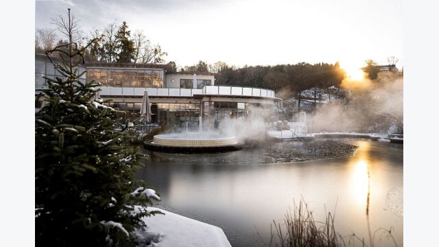 Außenansicht auf Heilthermen Resort Bad Waltersdorf im Winter, mit dampfendem, leicht zugefrorenem wasser