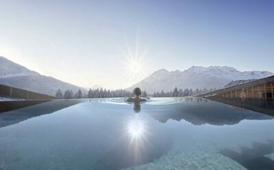 Rückansicht auf Frau im Infinity Pool im Hotel Carpe Solem Kaprun