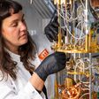 Frau in weißem Kittel arbeitet an einem Quantencomputer