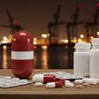 Tabletten und Kapseln in rot-weiß-roten Dosen mit Fluss und Industrie in abendlichem Hintergrund